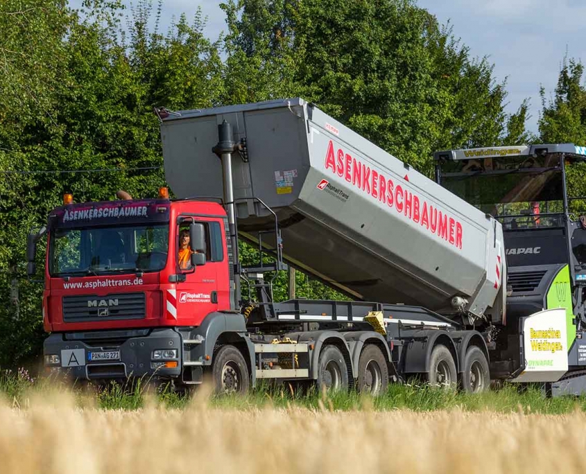 Ausbringen von Asphalt auf der Baustelle im Straßenbau Ausbringen von Asphalt auf der Baustelle im Straßenbau
